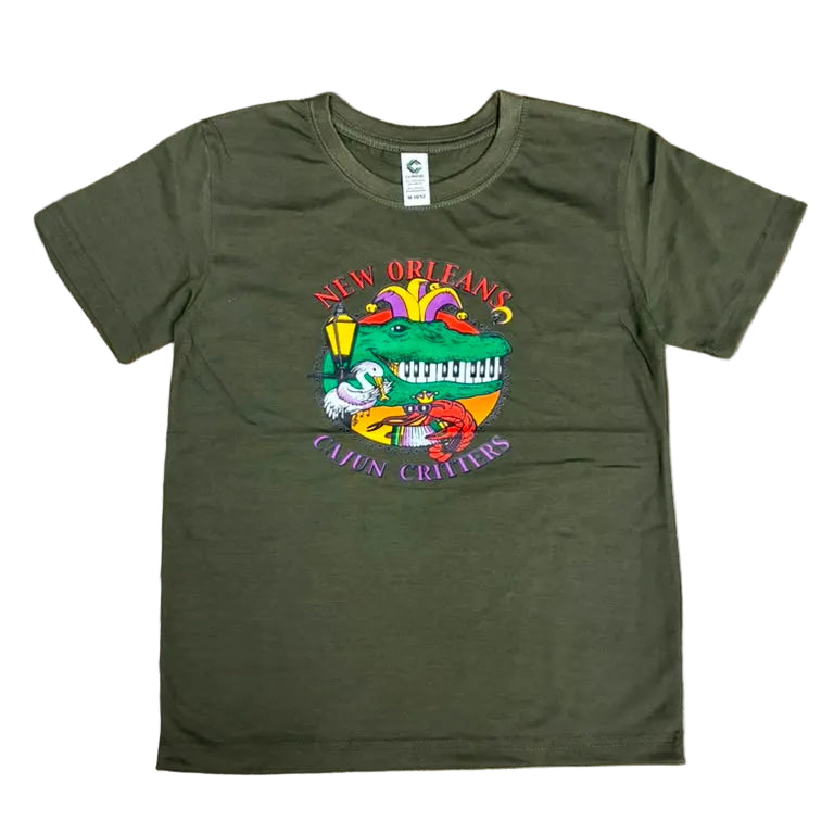An olive green short-sleeve t-shirt laid flat on a brown wooden floor, featuring a colorful graphic print on the front with the words 'CULTURE CRITTERS'