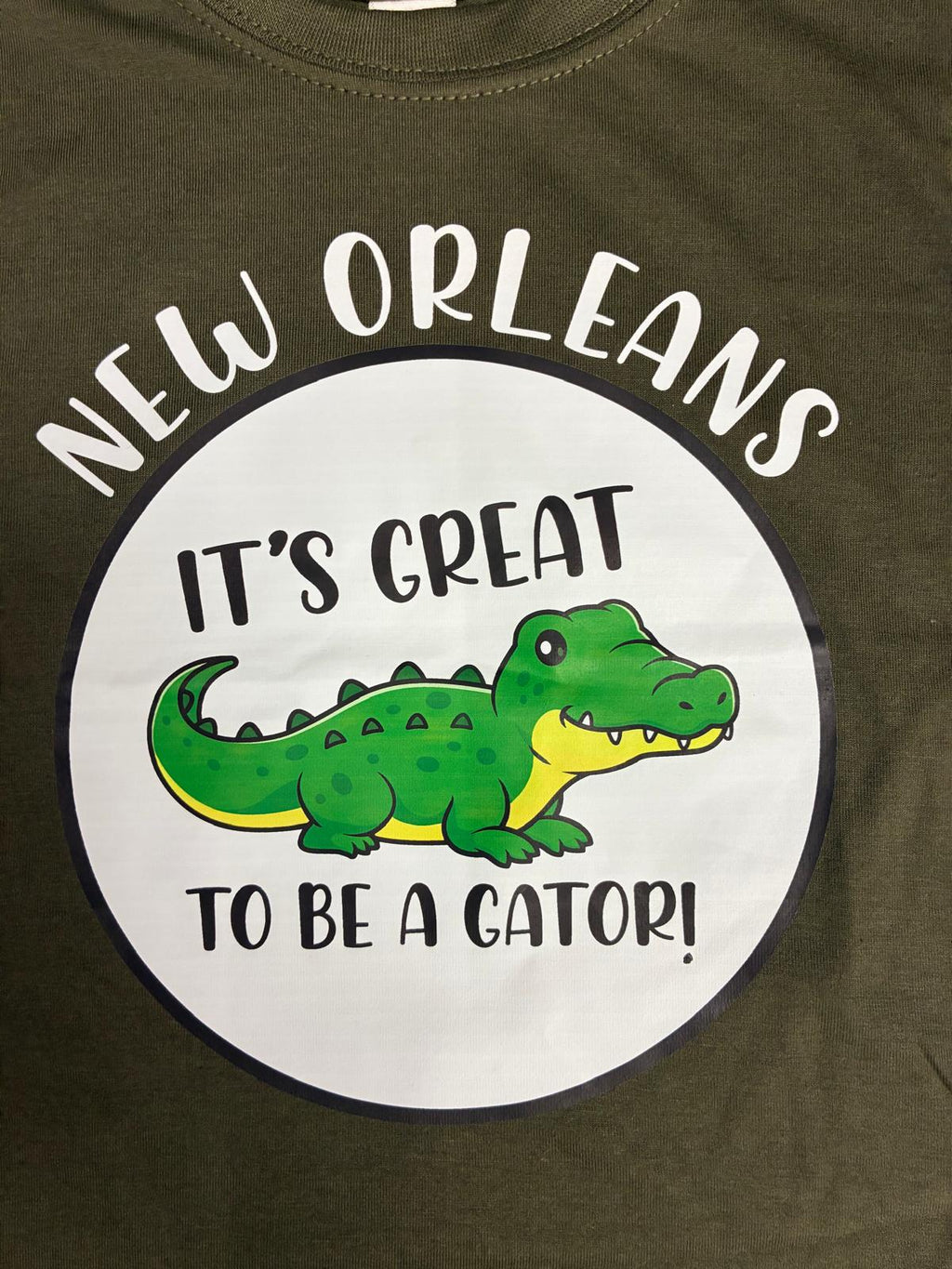 A close-up of the t-shirt design with New Orleans on top of the circle and a green gator inside with the words "It's Great to be a Gator!"