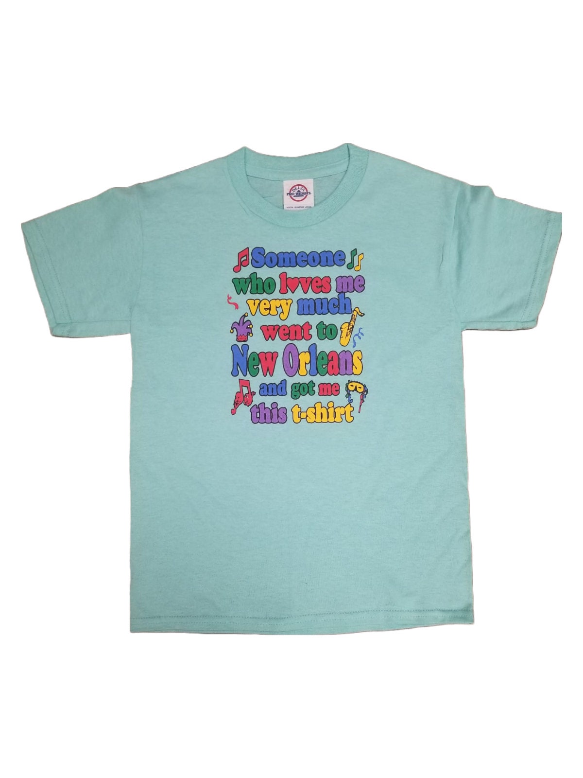 A light blue short-sleeve t-shirt with a colorful graphic text print on the front, displayed against a plain white background.