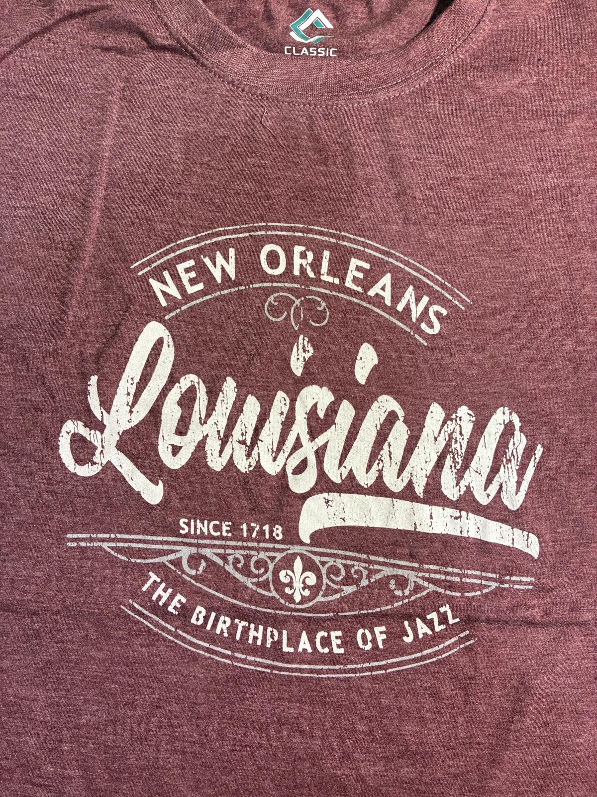A close-up of a heathered burgundy t-shirt featuring a distressed white graphic print that reads 'New Orleans Louisiana Since 1718 The Birthplace of Jazz'.