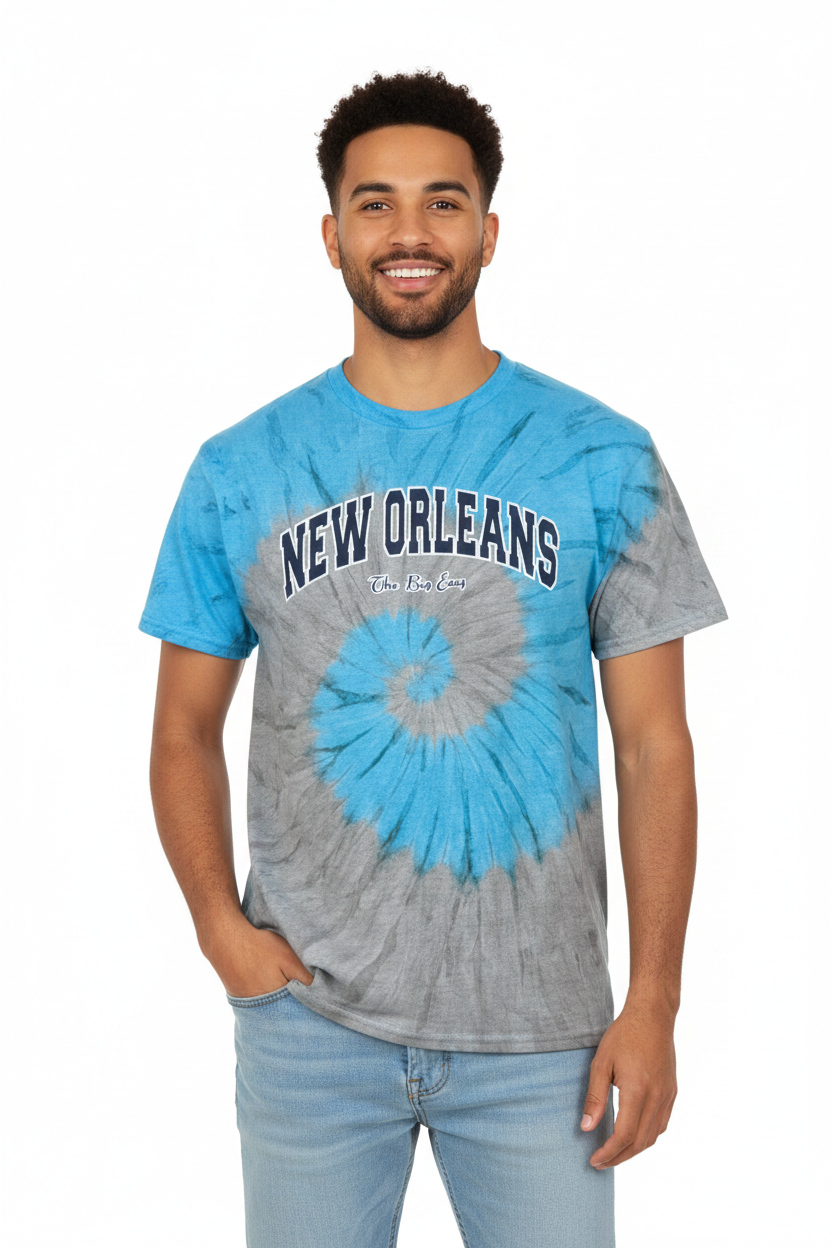 A man wearing a blue and gray spiral tie-dye t-shirt with 'NEW ORLEANS' printed across the chest, paired with light blue jeans, against a plain white background.