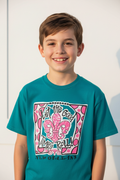 A smiling young boy wearing a teal short-sleeve graphic t-shirt with a pink and white fleur-de-lis design and the text 'Let the Good Times Roll' and 'NEW ORLEANS'.