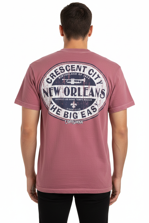 A man viewed from the back wearing a dusty rose short-sleeve t-shirt with a large circular graphic on the back that reads 'Crescent City New Orleans The Big East Louisiana'.