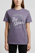 Faceless female model wearing a heather purple New Orleans graphic tee with distressed white script reading 'New Orleans Louisiana Since 1718 The Big Easy' — studio shot, gray background