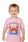 A smiling toddler wearing a light pink short-sleeve t-shirt with a colorful cartoon crab graphic and the text 'new orleans' and 'i'm a little crappy' on a plain white background.