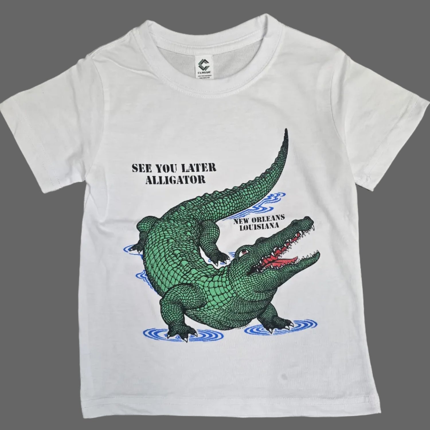 A white short-sleeve kids' t-shirt featuring a green alligator graphic with the text 'SEE YOU LATER, ALLIGATOR' and 'NEW ORLEANS LOUSIANA' on a white background